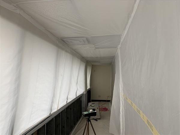 Section of room taped off with mold detection equipment monitoring the air in a mold remediation project overseen by Precision Environmental Services.